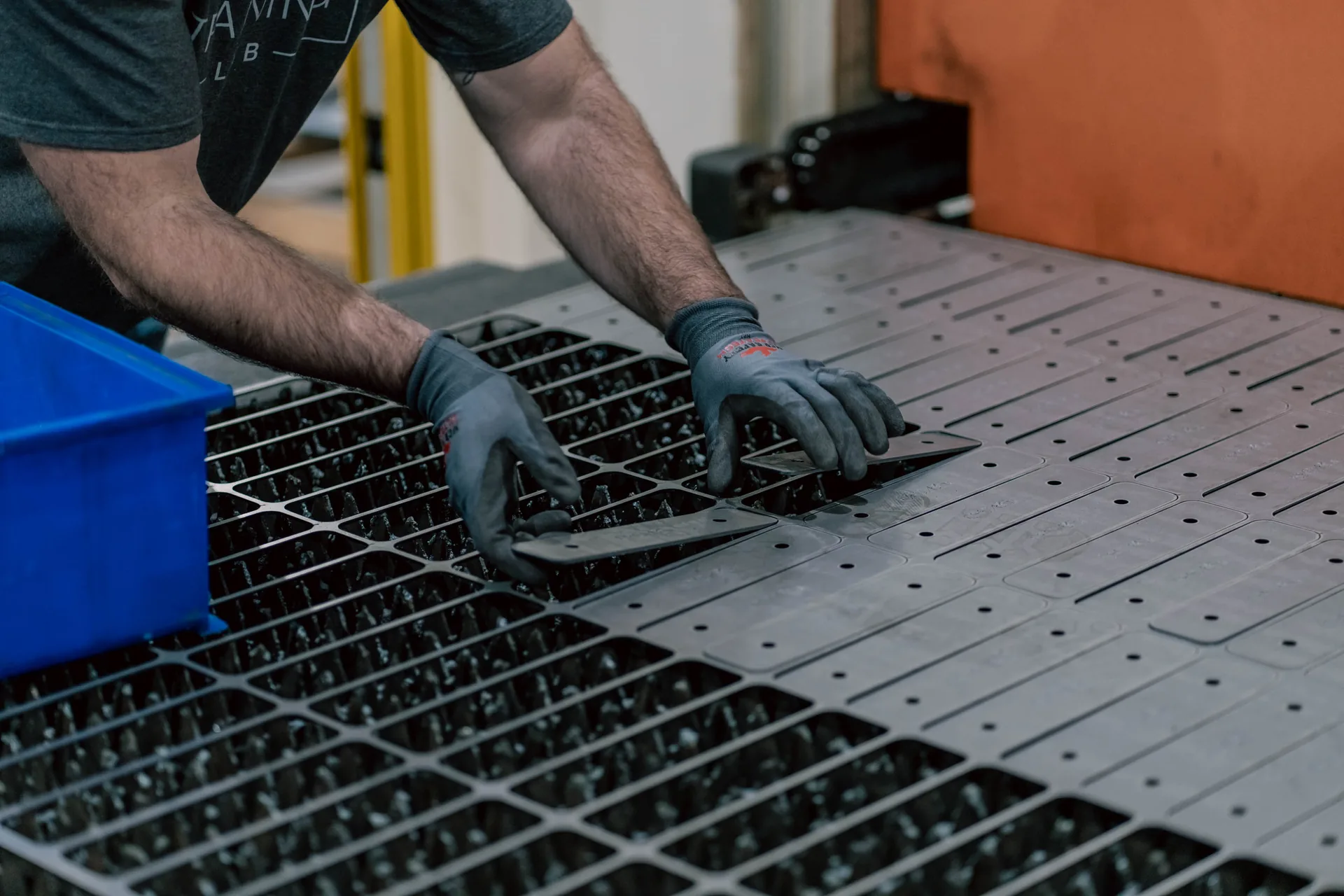 Operator unloading laser-cut parts from fiber laser bed